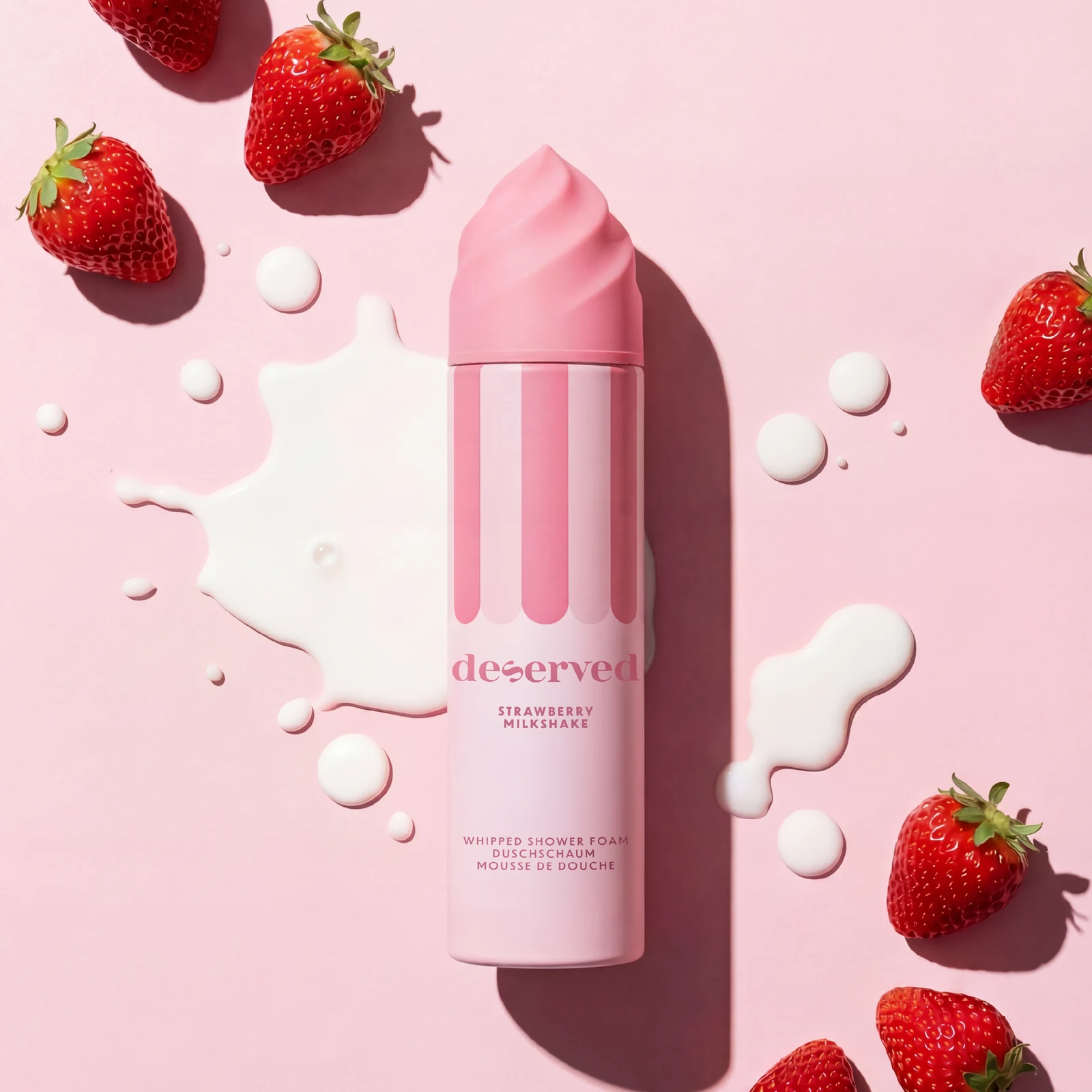 Sprchovacia pena Deserved Strawberry Milkshake na ružovom pozadí s jahodami